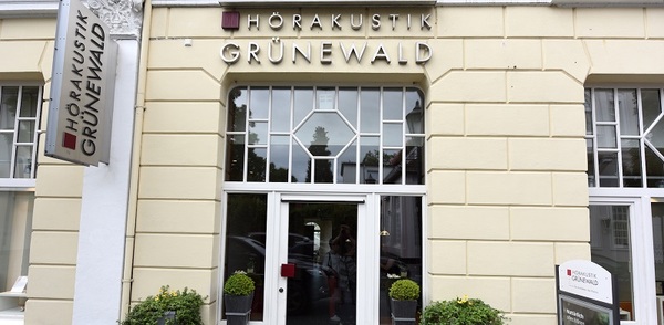 Das Geschäft Hörakustik Grünewald mit heller Fassade und großen Fenstern in der Innenstadt.
