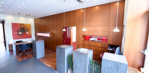 Moderne Zahnarztpraxis mit Holzwänden, Empfangsbereich und stilvoller Innenausstattung.